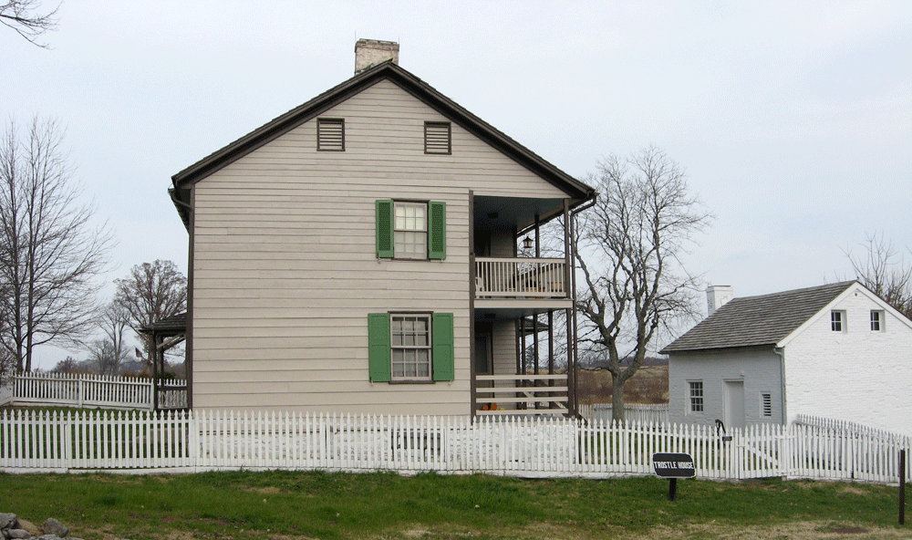 The side of the Troste House along United States Avenue and an outbuiling