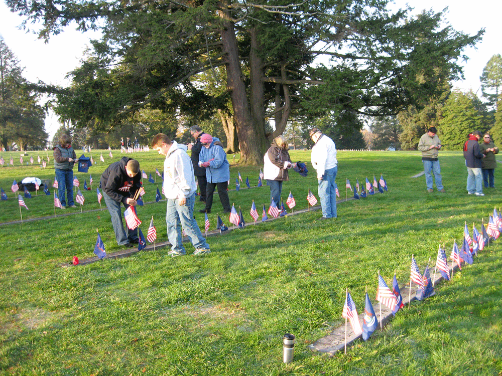 Volunteers place flags in the National Cemetery